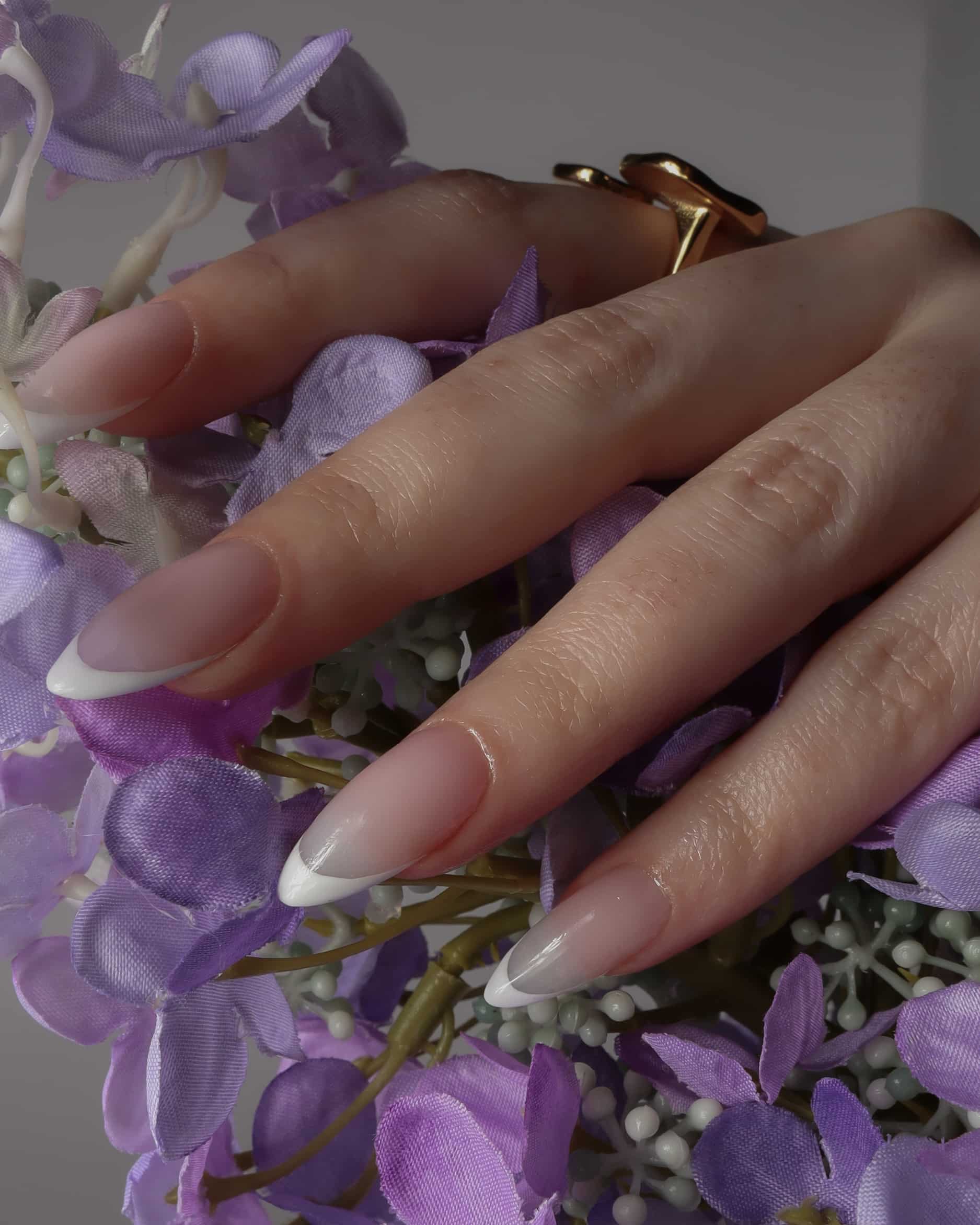 White French nails with modeling hands holding flowers by Inglass Nails. Reusable nail extensions. 
